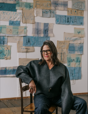 Marie Watt with Untitled—Work in Progress, 2022, consisting of panels from Whitney Sewing Circles. Photographed in Portland, Oregon, December 2022. Styled by Rachael Wang. Watt wears a Toteme sweater from Frances May; Chimala jeans from Frances May; her own glasses and jewelry.